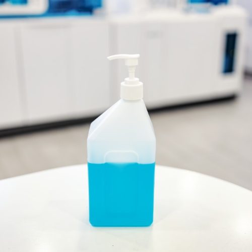 Production and testing sanitizer. A bottle with disinfecting liquid on a table in a lab is ready to be tested.